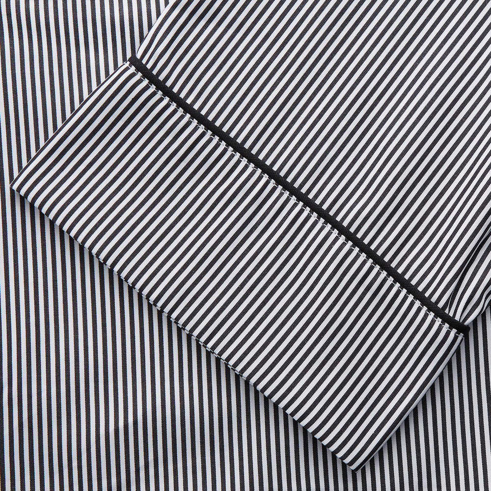The Turnbull & Asser Black Candy Stripe Cotton Hyde Pyjama Set for men features soft cotton striped pajamas with a long-sleeve, button-up shirt detailed with black piping and three pockets, plus matching pants, both laid flat on a white background.