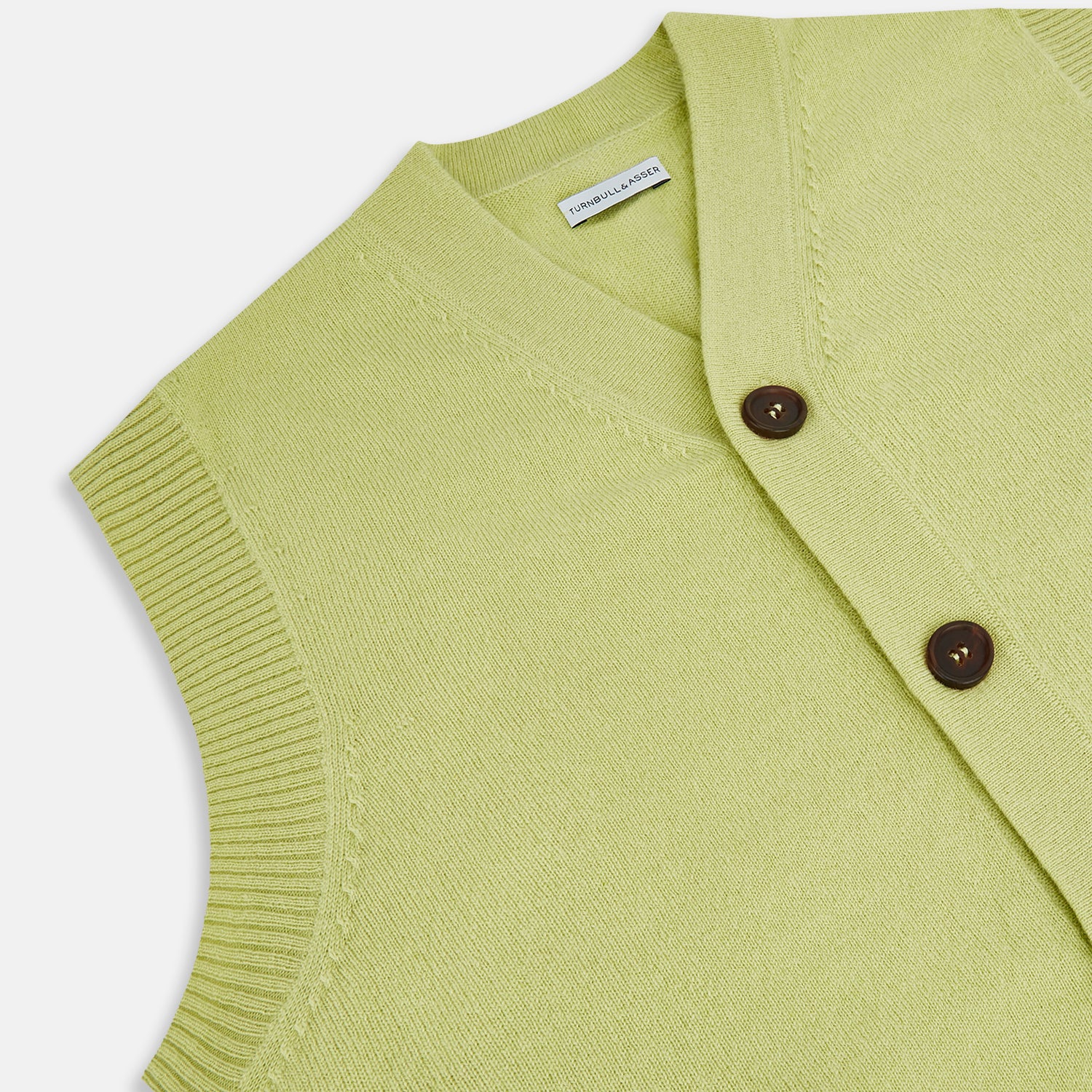 View 2 of product The Melon Green Sleeveless Cardigan by Turnbull & Asser features a ribbed collar, large brown buttons, and two front pockets—a stylish layering piece shown against a plain white background.