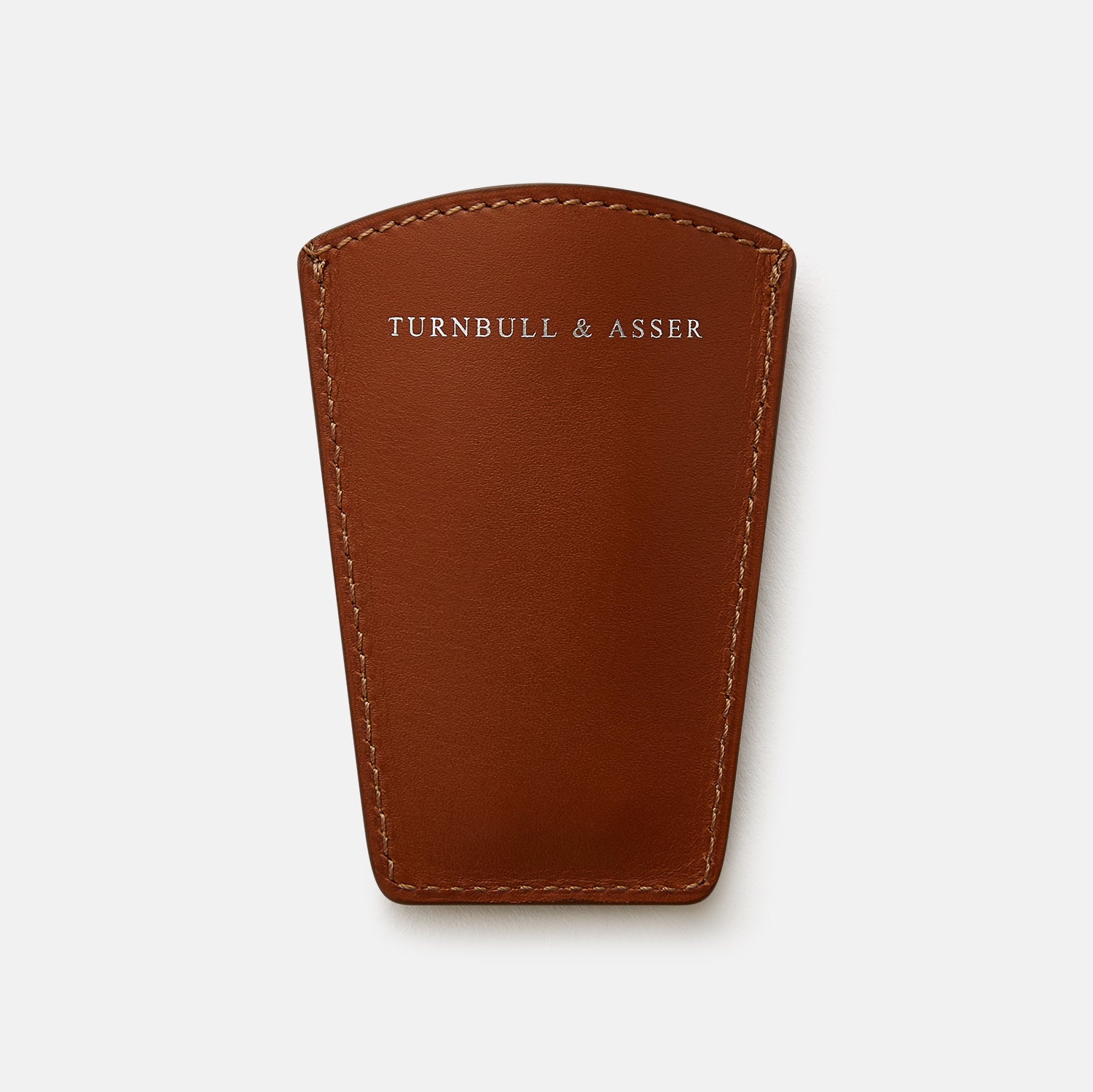 View 4 of product The Turnbull & Asser Camel Travel Shoe Horn features a wide, shiny silver blade and a brown Italian leather handle, displayed on a plain light background.