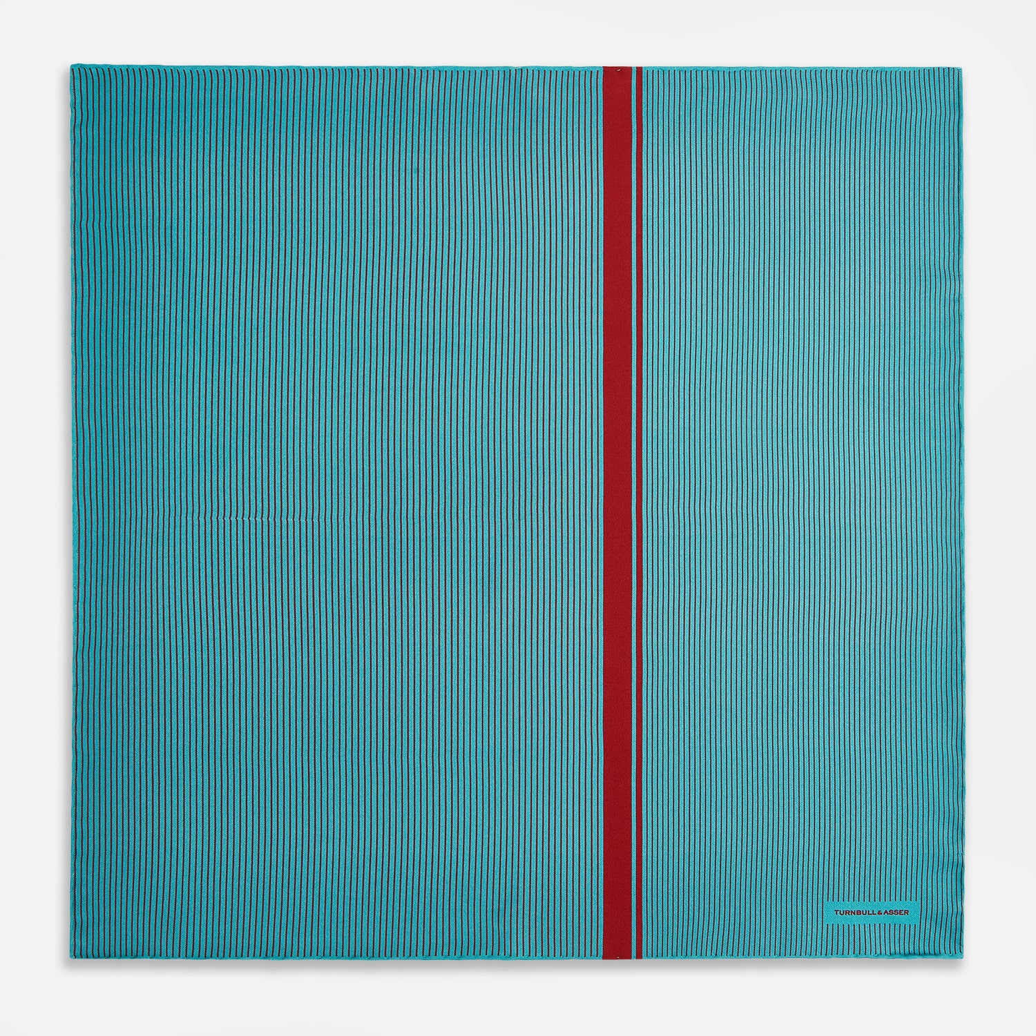 View 4 of product The Turnbull & Asser Turquoise and Red Stripe Silk Pocket Square features thin navy stripes with a bold vertical red stripe, partially folded to reveal the reverse pattern and the brand's logo, showcasing its British heritage.