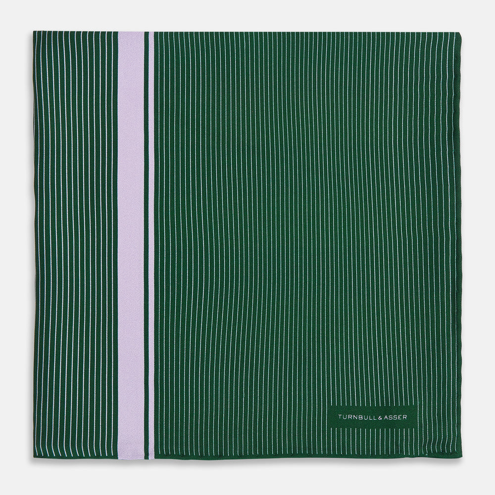 The Forest Green and Lilac Stripe Silk Pocket Square by Turnbull & Asser features thin white pinstripes, a bold light purple vertical stripe, and a visible branded label for classic British elegance. One corner is neatly folded over.