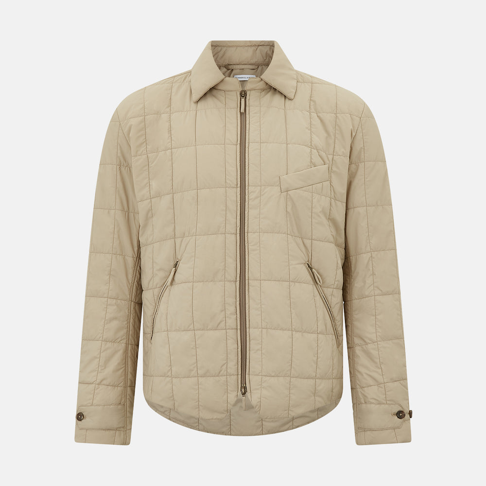 The Battersea Sand Quilted Jacket by Turnbull & Asser is a light beige men's jacket with a front zipper, pointed collar, zippered side pockets, chest pocket, and buttoned cuffs, shown on a plain white background.