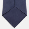 View 2 of product The Turnbull & Asser Navy Gold Embroidered Botanical Tie features intricate gold botanical embroidery on navy blue silk, neatly rolled with the detailed tip facing forward.