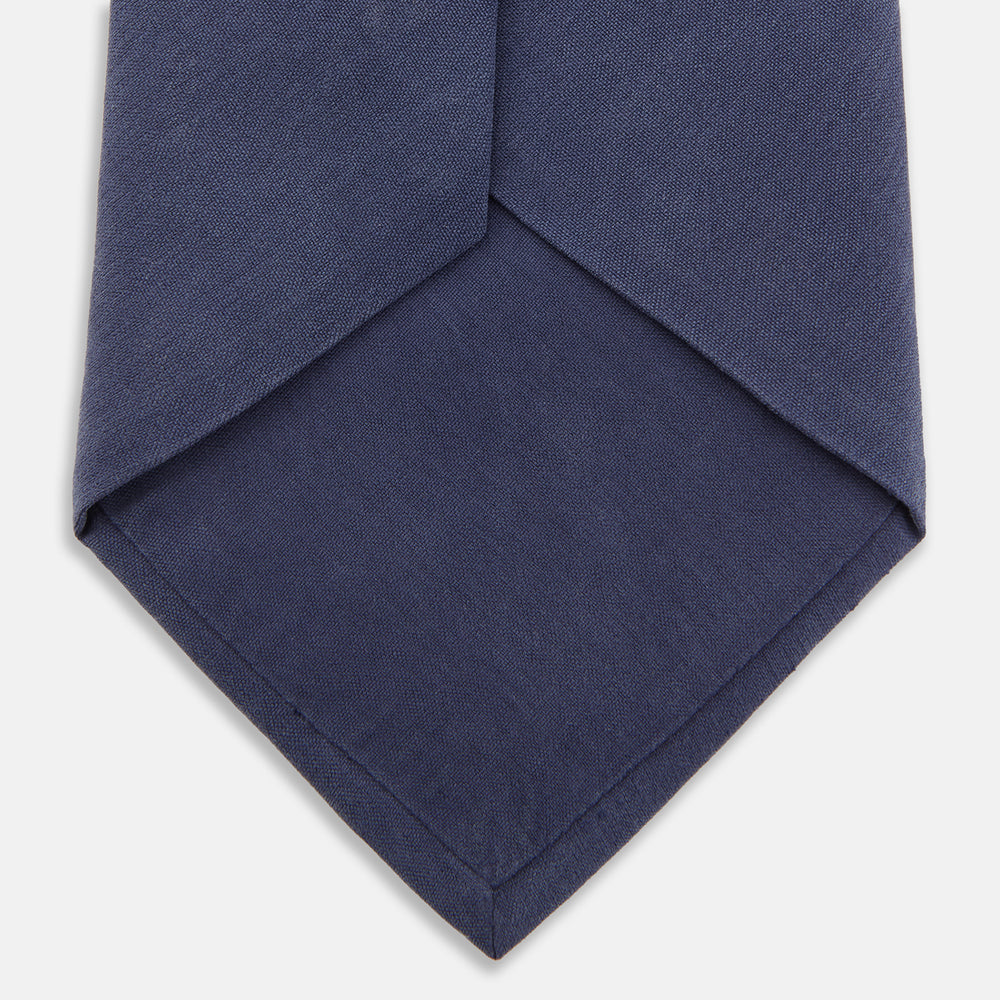 The Turnbull & Asser Navy Gold Embroidered Botanical Tie features intricate gold botanical embroidery on navy blue silk, neatly rolled with the detailed tip facing forward.