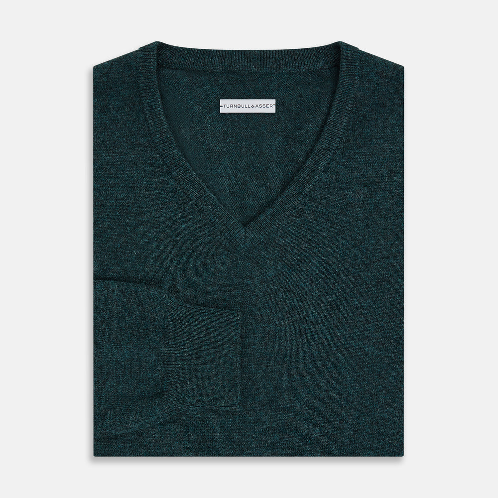 The Turnbull & Asser Forest Green Cashmere V-Neck Jumper features long sleeves, ribbed cuffs, collar, and hem. Shown against a white background, it's a classic knitwear piece ideal for layering.