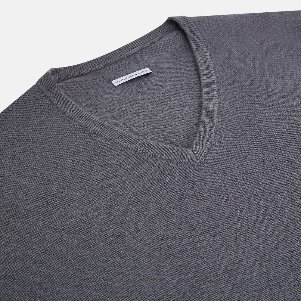 The Grey V-Neck Cashmere Jumper by Turnbull & Asser features long sleeves, ribbed cuffs and hem, in dark gray cashmere, shown against a white background.
