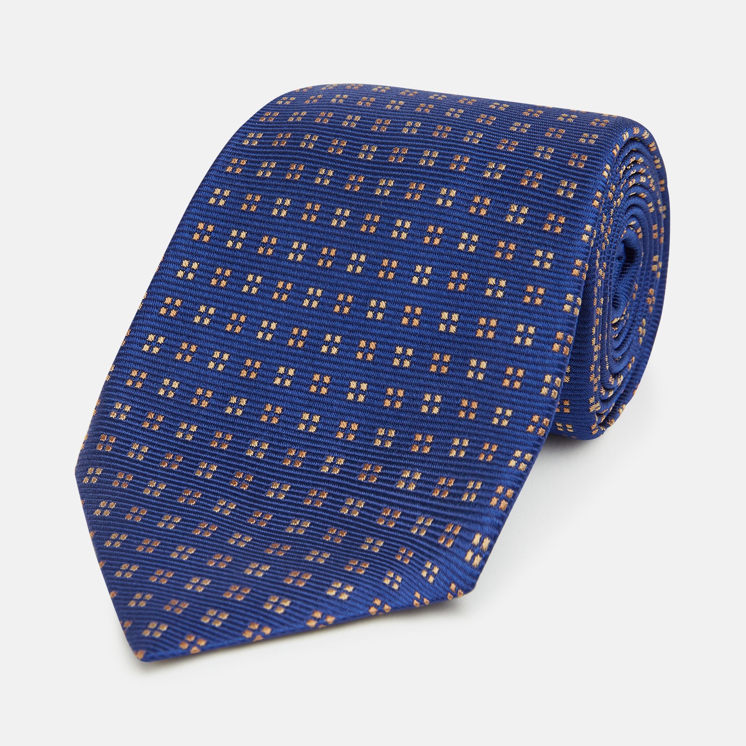 View 1 of product The Turnbull & Asser Bronze and Blue Multi Dot Silk Tie features a refined blue background with multicolored dots, elegantly displayed on a plain white backdrop—an ideal choice for a modern office look.