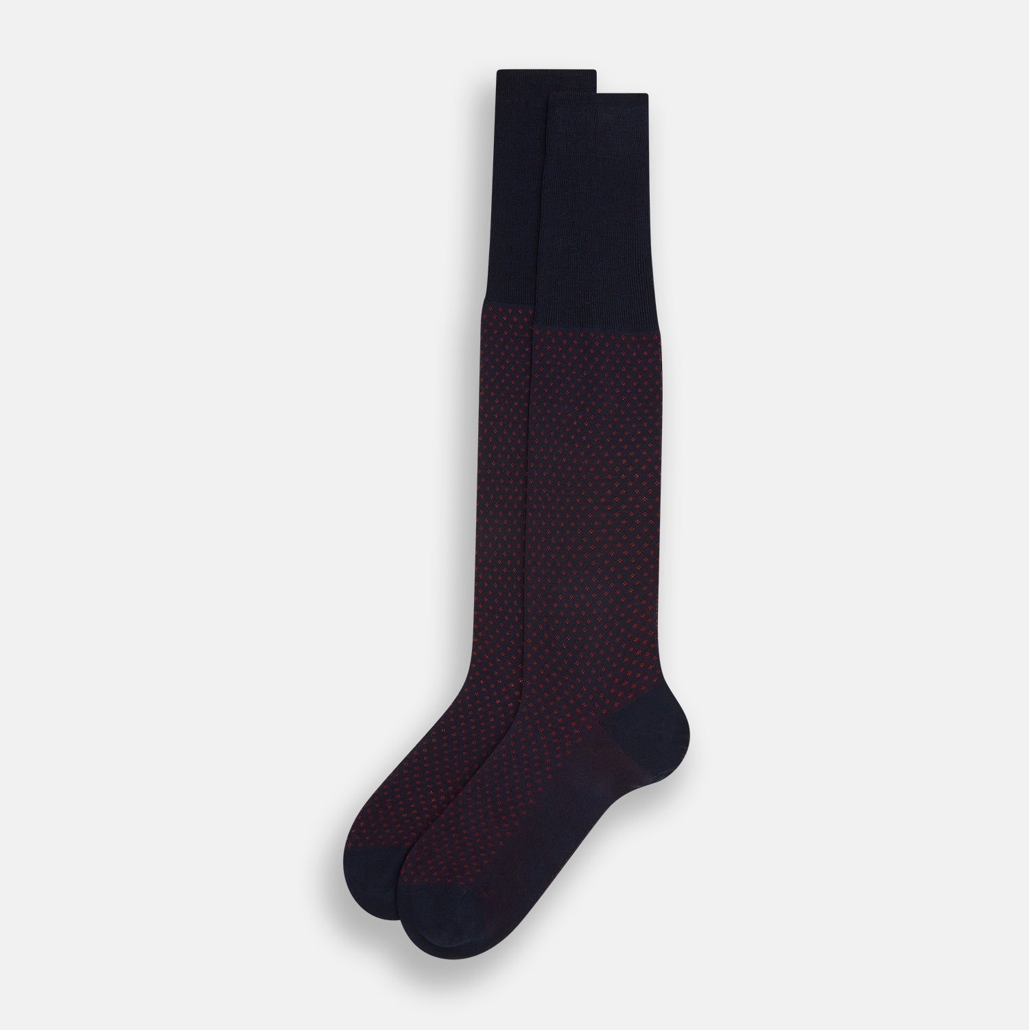 View 2 of product The Turnbull & Asser Navy/Red Motif Long Sock is crafted from mercerised Egyptian cotton, featuring a subtle red and navy diamond pattern with a solid navy cuff, heel, and toe, displayed on a white background.