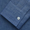 View 4 of product The Blue Weekend Fit Linen Finch Shirt by Turnbull & Asser features a Derby collar, chest pocket, and white buttons. Made from mid-blue linen chambray, it offers effortless casual style when laid flat on a plain white background.