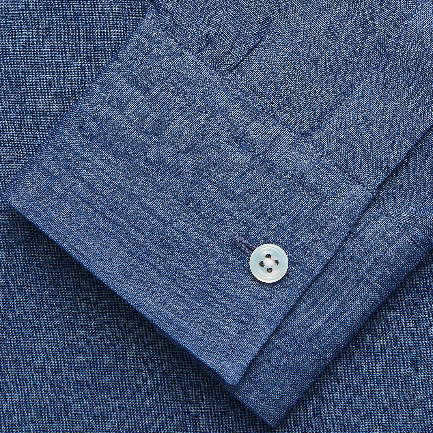 View 4 of product The Blue Weekend Fit Linen Finch Shirt by Turnbull & Asser features a Derby collar, chest pocket, and white buttons. Made from mid-blue linen chambray, it offers effortless casual style when laid flat on a plain white background.