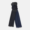 View 1 of product The Charcoal and Navy Cashmere Scarf by Turnbull & Asser features a color block design in dark hues, raw fringed edges, and a soft, smooth texture, elegantly displayed against a white background.