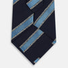 View 3 of product The Turnbull & Asser Navy Multi Stripe Silk Tie features diagonal light blue and silver stripes on an English silk navy base, rolled neatly against a white background.
