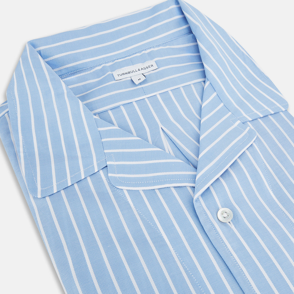 The Turnbull & Asser White and Blue Stripe Quarzo Nightshirt features long sleeves, a collar, button-up front, chest pocket, and mid-length hem—a classic men's striped sleepwear piece.