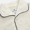 View 2 of product The Cream Pattern Cotton Blend Quin Pyjama Set by Turnbull & Asser features cream stripes, a long-sleeve button-up camp collar shirt with a chest pocket and black piping, and matching drawstring pants.