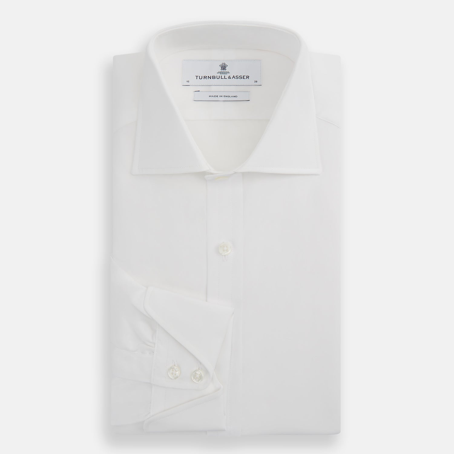 View 5 of product The Turnbull & Asser White Poplin Shirt With Regent Collar and 2-Button Cocktail Cuffs, featuring long sleeves, is buttoned up and laid flat on a white background.