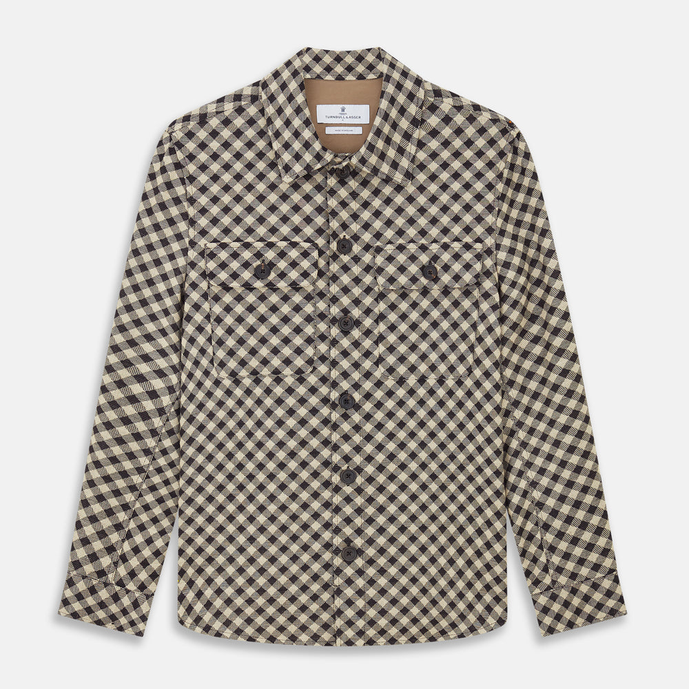 The Turnbull & Asser Black Gingham Check Wool Blend Somerset Overshirt features long sleeves, two chest flap pockets with buttons, and a black-and-beige check pattern. Shown laid flat on a white background; ideal as transitional outerwear.