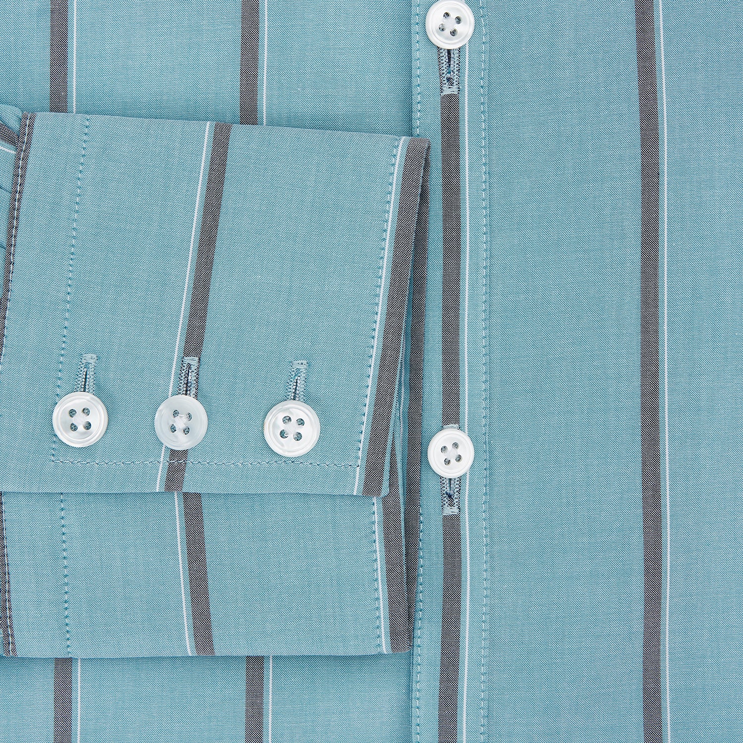 View 4 of product The Cendre Blue Track Stripe Westminster Shirt by Turnbull & Asser features a light blue hue, dark vertical stripes, button-down front, classic collar, and buttoned cuffs—showcasing British craftsmanship.