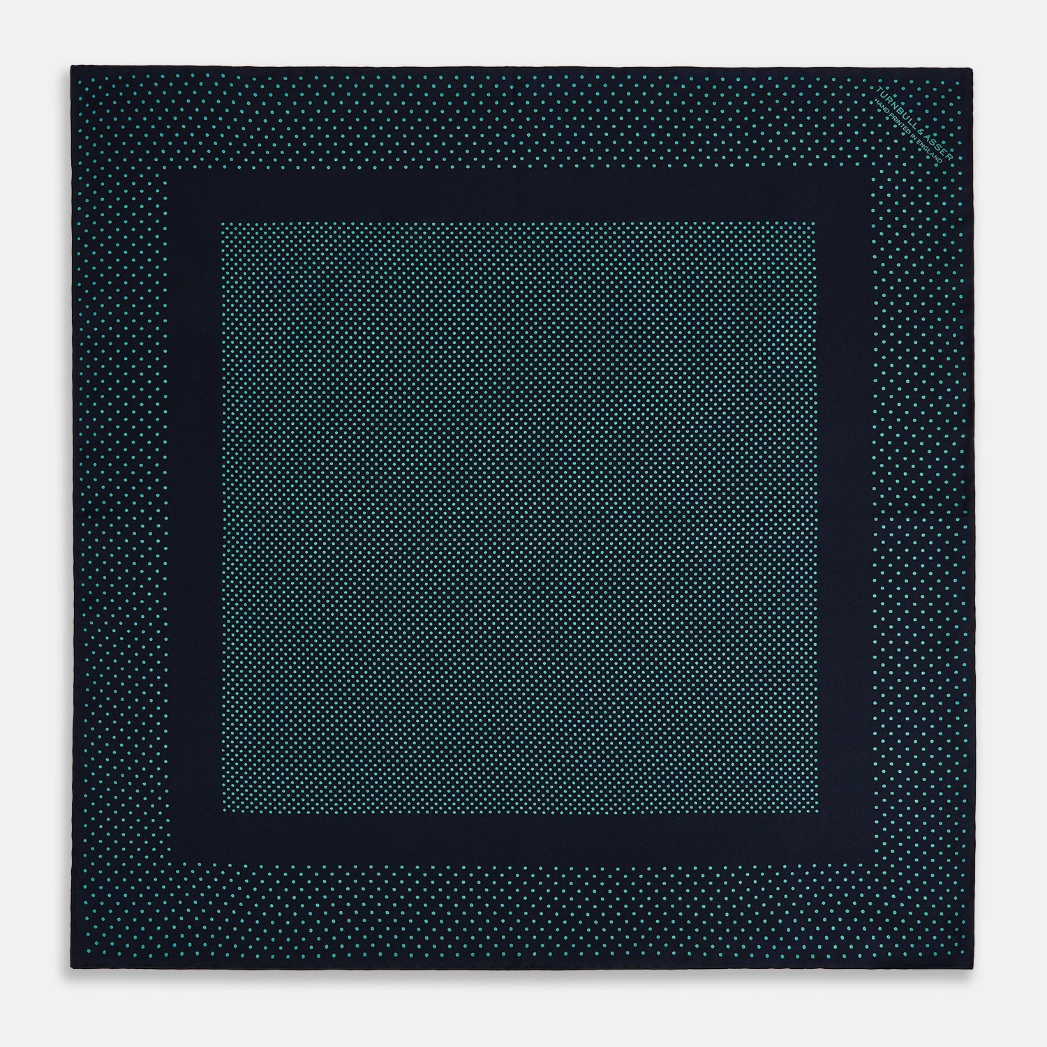 View 3 of product The Turnbull & Asser Navy and Petrol Green Dot Silk Pocket Square features handmade craftsmanship with petrol green polka dots and a darker border, elegantly displayed on a white background.