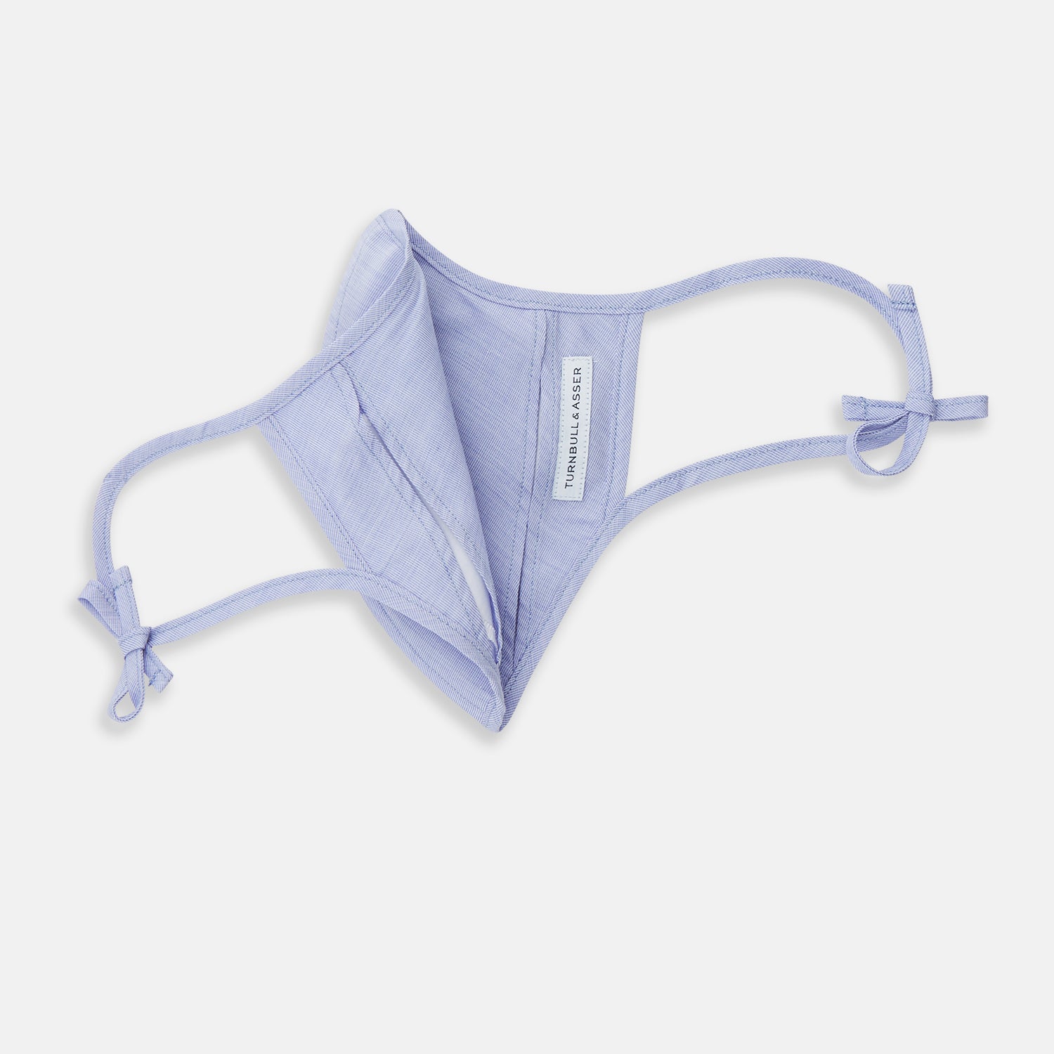 View 5 of product The Turnbull & Asser Plain Pale Blue Commuter Mask with 3 Viroformula™ filters features adjustable ear loops and side ties—ideal for daily use, shown against a white background.