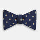 The Blue and Yellow Links Silk Bow Tie by Turnbull & Asser features a subtle wavy texture with a refined pattern of interlinked gold, blue, and white rings—an elegant accessory to enhance any formal outfit.