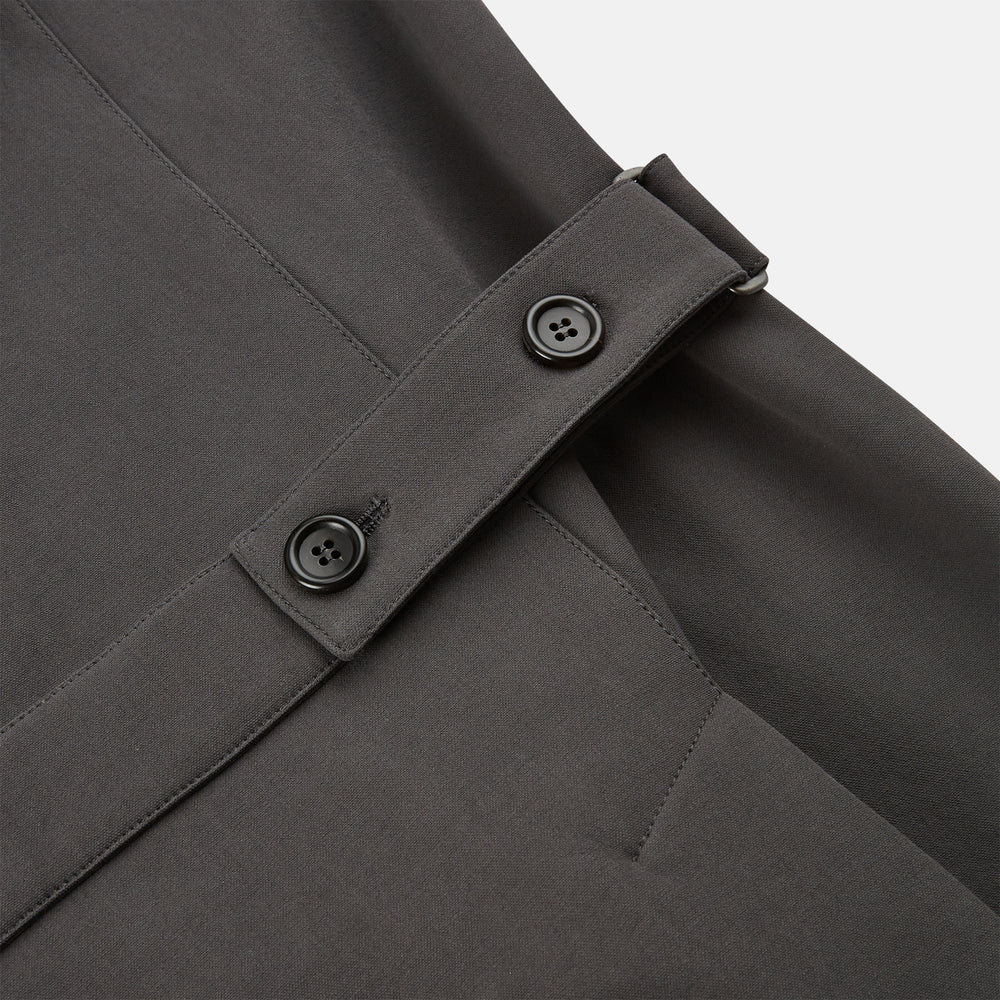The Turnbull & Asser Charcoal Melange John Arthur Trench Coat, featuring a collar, single-breasted closure, and three zippered pockets—one chest and two at the hips—is shown against a plain white background.