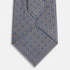 View 3 of product The Turnbull & Asser Silver and Pale Blue Multi Dot Silk Tie features elegant small dots on light brown silk, ideal for modern office wear, shown rolled up against a white background.