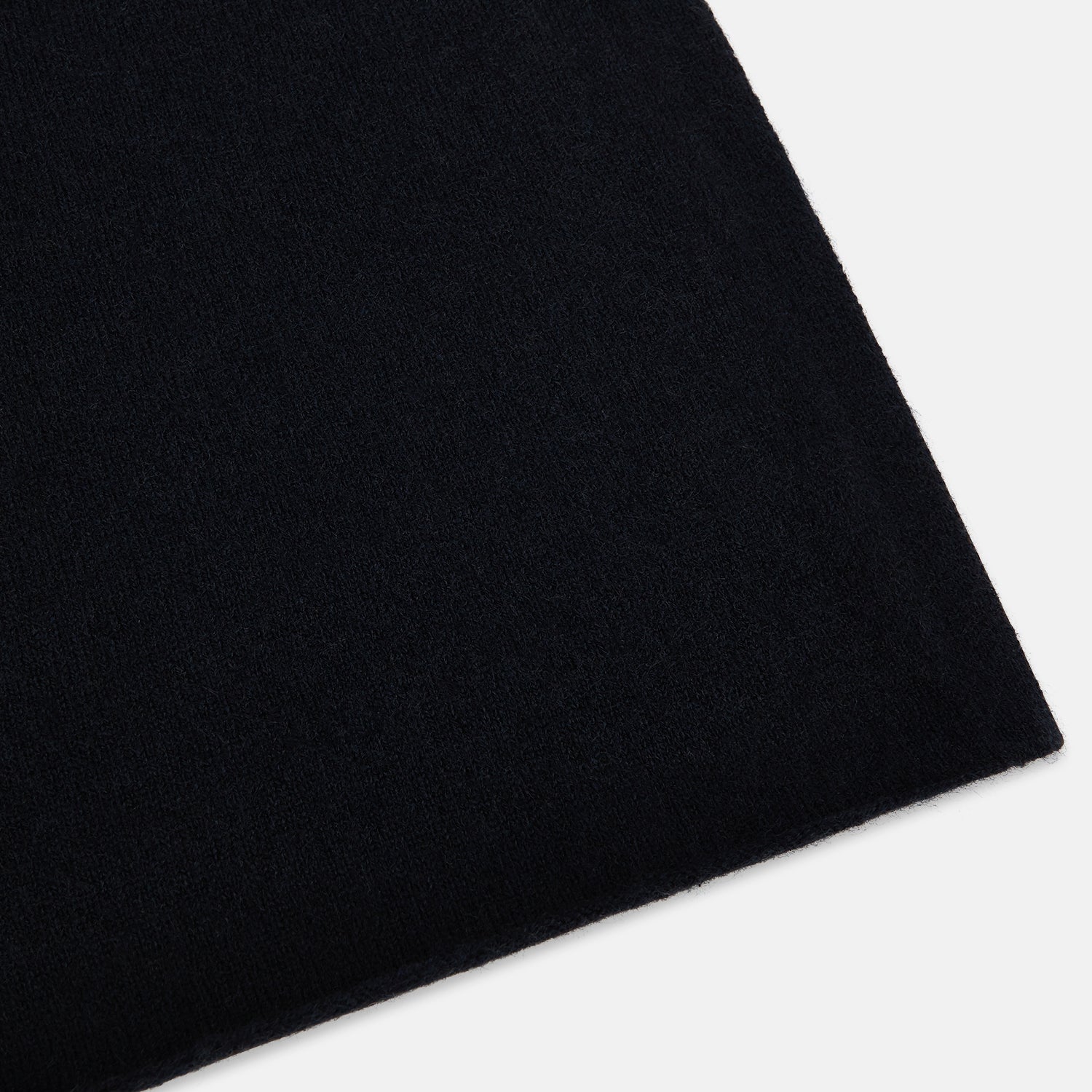 View 2 of product The Turnbull & Asser Plain Navy Cashmere Knitted Scarf is shown looped against a white background, highlighting its soft texture and elegant drape.