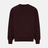 View 8 of product The Turnbull & Asser Burgundy Fine Merino V-Neck Jumper features a classic plain knit design with long sleeves, showcased against a crisp white background.