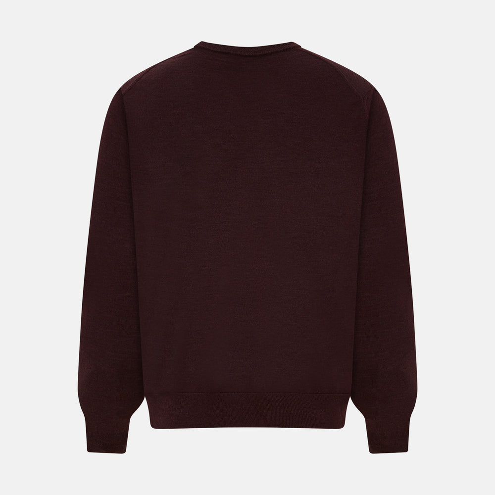 The Turnbull & Asser Burgundy Fine Merino V-Neck Jumper features a classic plain knit design with long sleeves, showcased against a crisp white background.