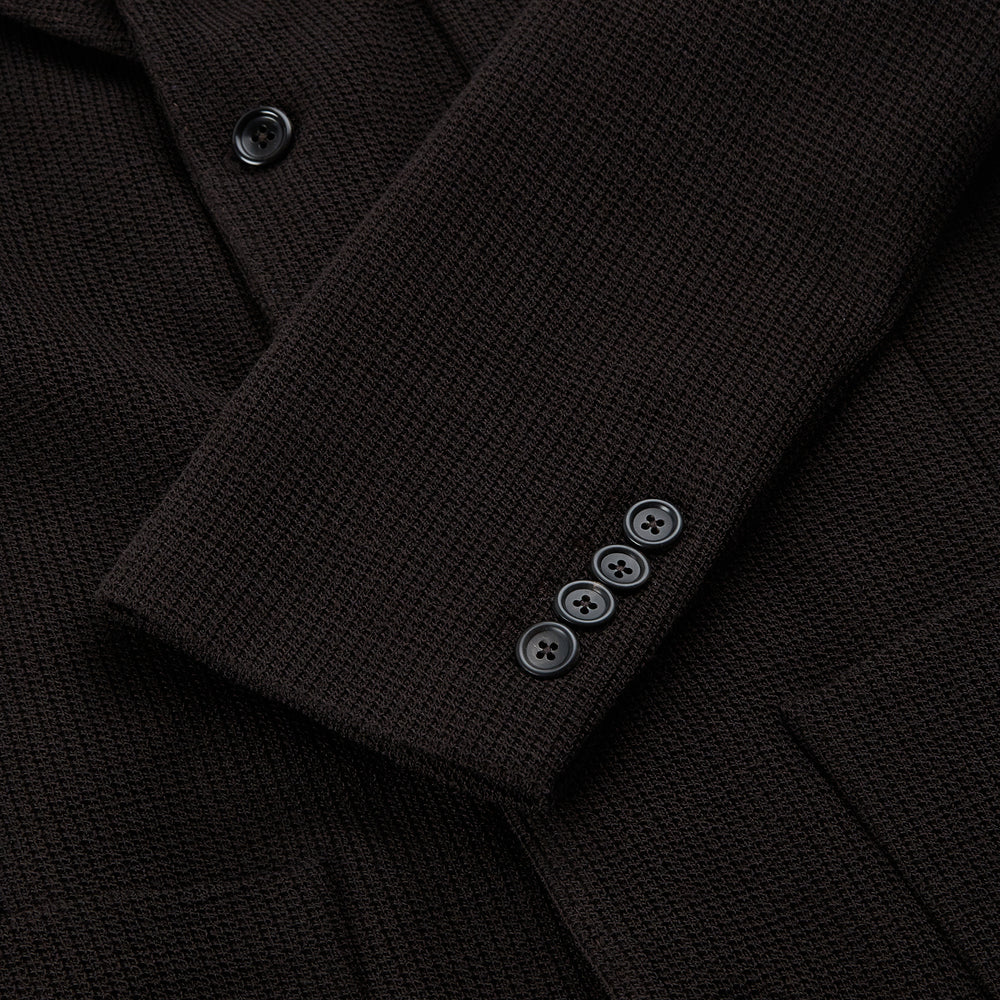 The Turnbull & Asser Dark Chocolate Knitted Cambridge Blazer for men, made from fine Italian wool with British tailoring, features a notched lapel, three front buttons, and three patch pockets, shown on a plain white background.