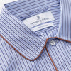 View 4 of product The Blue and Navy Halo Stripe Cotton Sussex Nightshirt by Turnbull & Asser features long sleeves, a collar, button-down front, chest pocket, curved hem, and brown piping for a classic luxury sleepwear style.