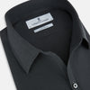 View 2 of product The Charcoal Windsor Shirt by Turnbull & Asser is a black, long-sleeve button-up with a pointed Windsor collar, buttoned cuffs, and a straight hem, shown flat on a white background.