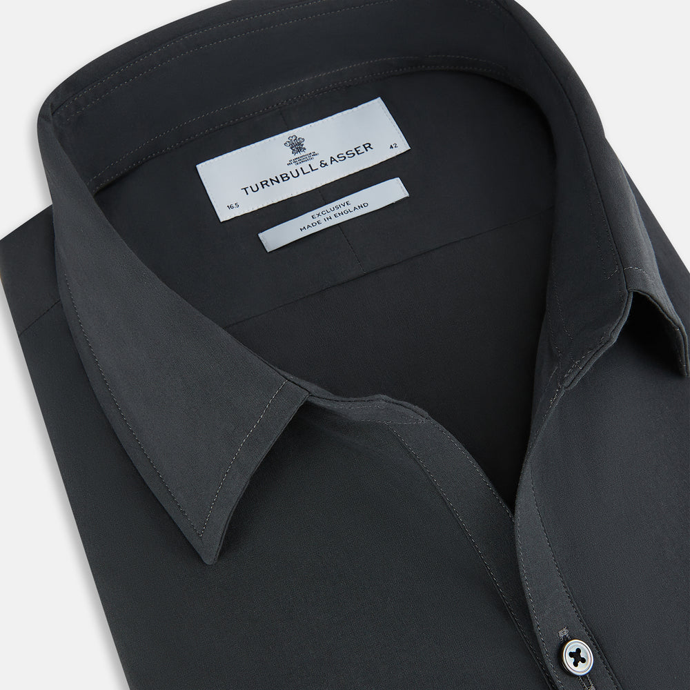 The Charcoal Windsor Shirt by Turnbull & Asser is a black, long-sleeve button-up with a pointed Windsor collar, buttoned cuffs, and a straight hem, shown flat on a white background.