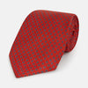 View 1 of product The Turnbull & Asser Red and Blue Square-Patterned Silk Tie is rolled up on a plain white background.