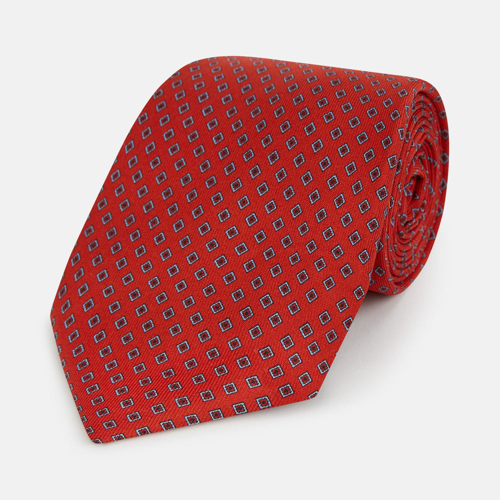 The Turnbull & Asser Red and Blue Square-Patterned Silk Tie is rolled up on a plain white background.