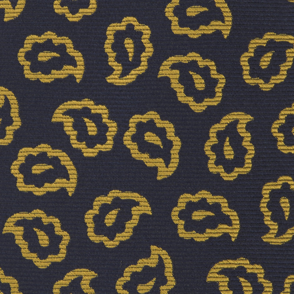 The Navy and Gold Petal Paisley Silk Tie by Turnbull & Asser features a repeating yellow abstract pattern, neatly rolled on a white background.