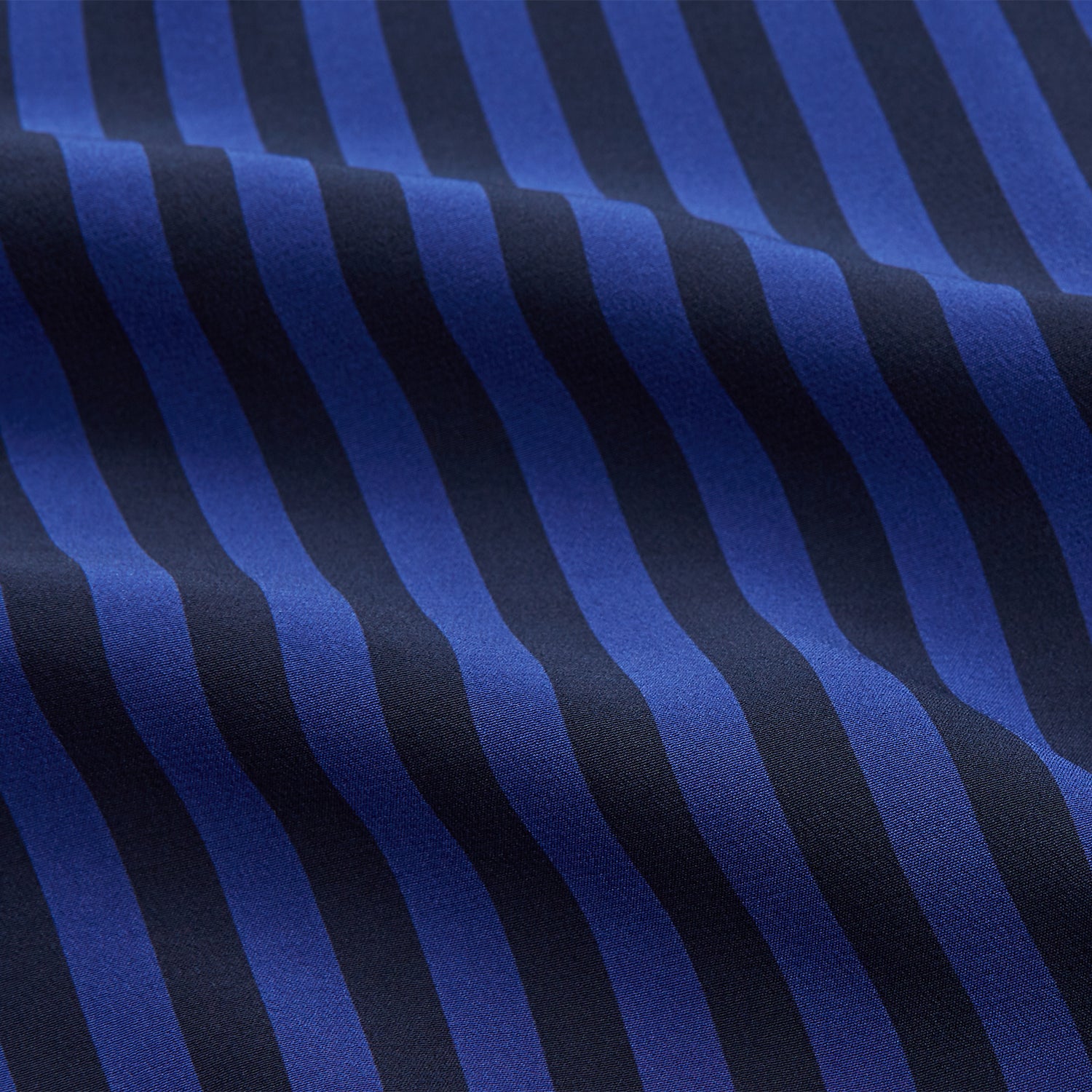View 2 of product The Turnbull & Asser Blue and Navy Candy Stripe Silk Hyde Pyjamas Set features a long-sleeve button-up top with a chest pocket and elastic-waist pants, shown on a plain white background.