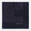 View 1 of product A navy silk pocket square with thin, even purple stripes and hand-rolled edges from Turnbull & Asser, featuring "Turnbull & Asser Hand Printed in England" printed in the corner.