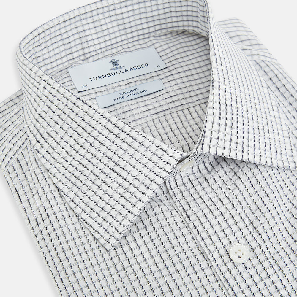 The Midnight Blue Multi Check Mayfair Shirt by Turnbull & Asser is a pure cotton, long-sleeve button-down featuring a small blue multi-check pattern, pointed collar, and buttoned cuffs.
