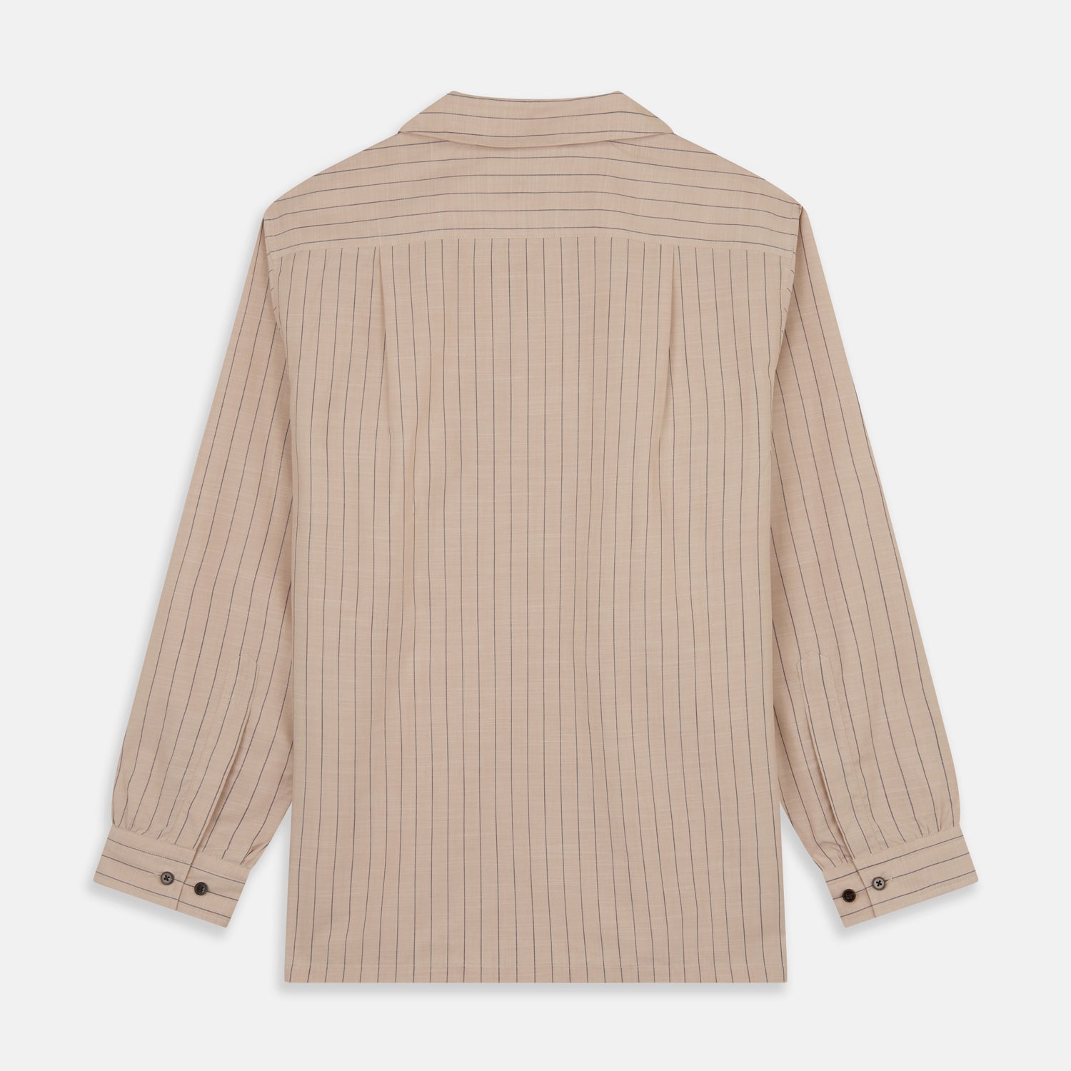 View 7 of product An older man in a light hat, Turnbull & Asser Beige Stripe Cotton Holiday Fit Shirt with Revere Collar & Single Button Cuff, and white pants leans casually against a tall concrete pillar outdoors, greenery blurred behind him.