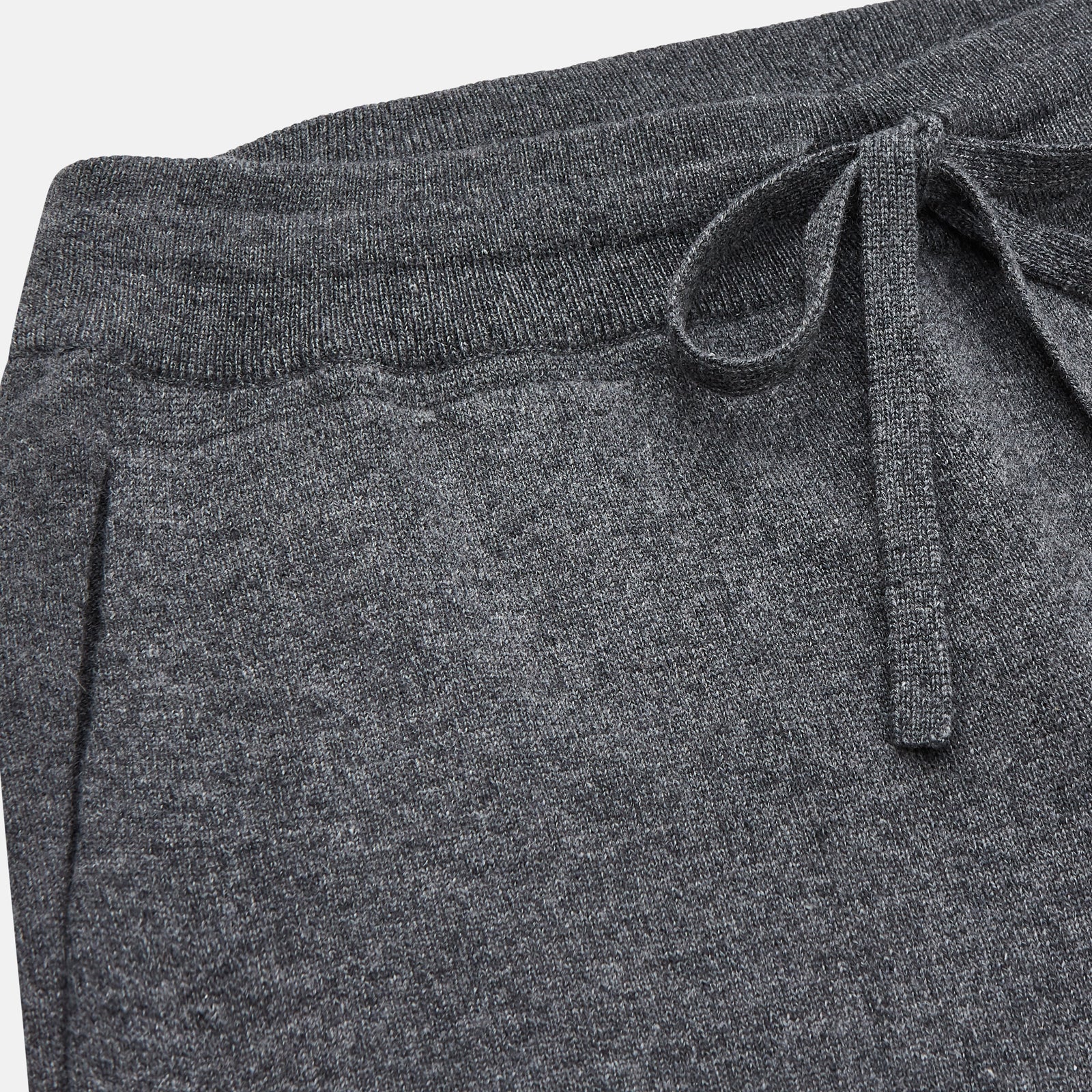 View 2 of product The Turnbull & Asser Grey Cashmere Knitted Lounge Pyjama Trousers feature an elastic waistband with drawstring, side pockets, and elastic cuffs at the ankles, shown laid flat on a white background.