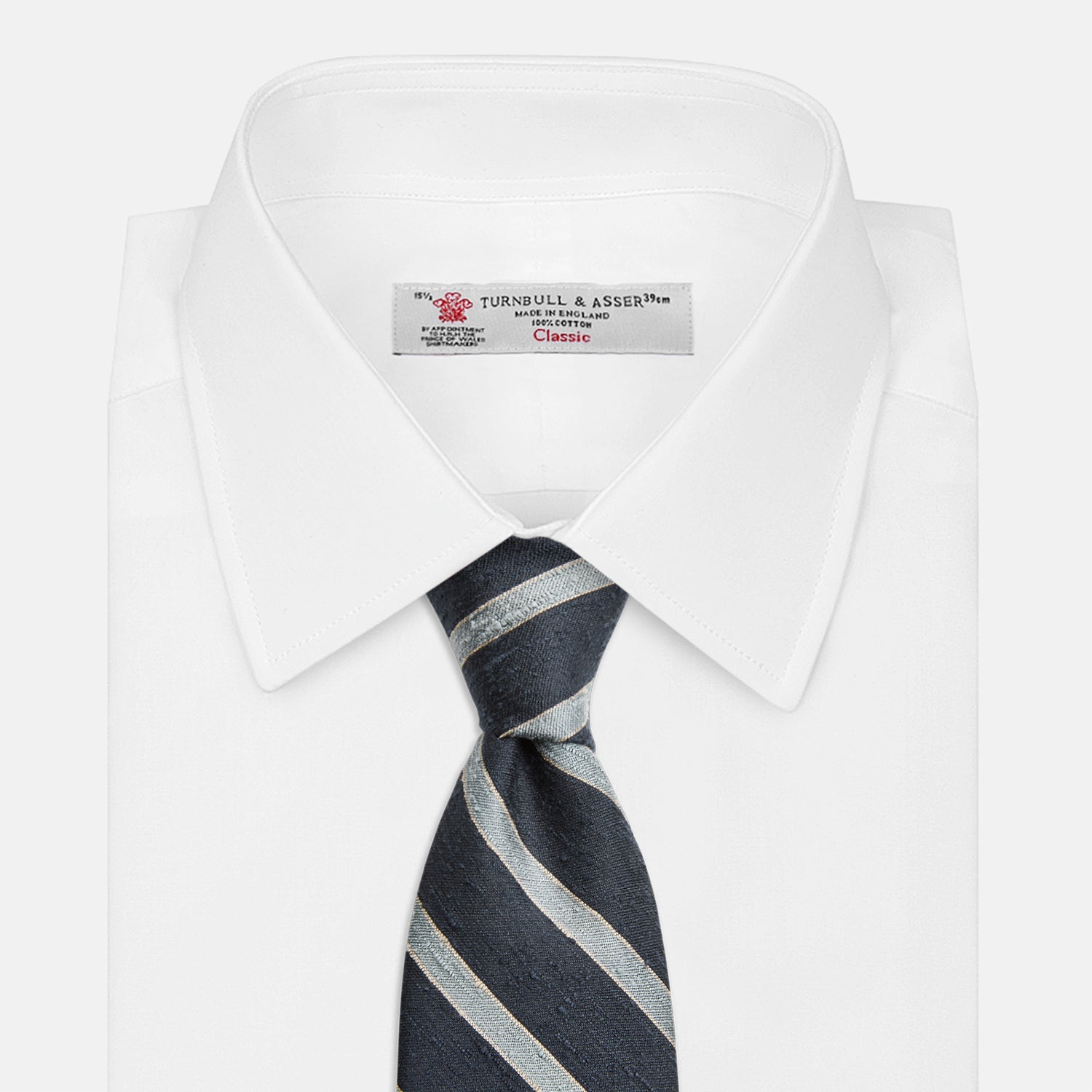 View 2 of product The Turnbull & Asser Blue & Silver Stripe Silk Tie, featuring wide diagonal stripes, is rolled up and displayed against a plain white background.