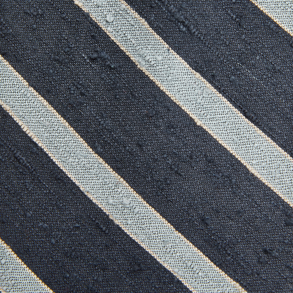 The Turnbull & Asser Blue & Silver Stripe Silk Tie, featuring wide diagonal stripes, is rolled up and displayed against a plain white background.