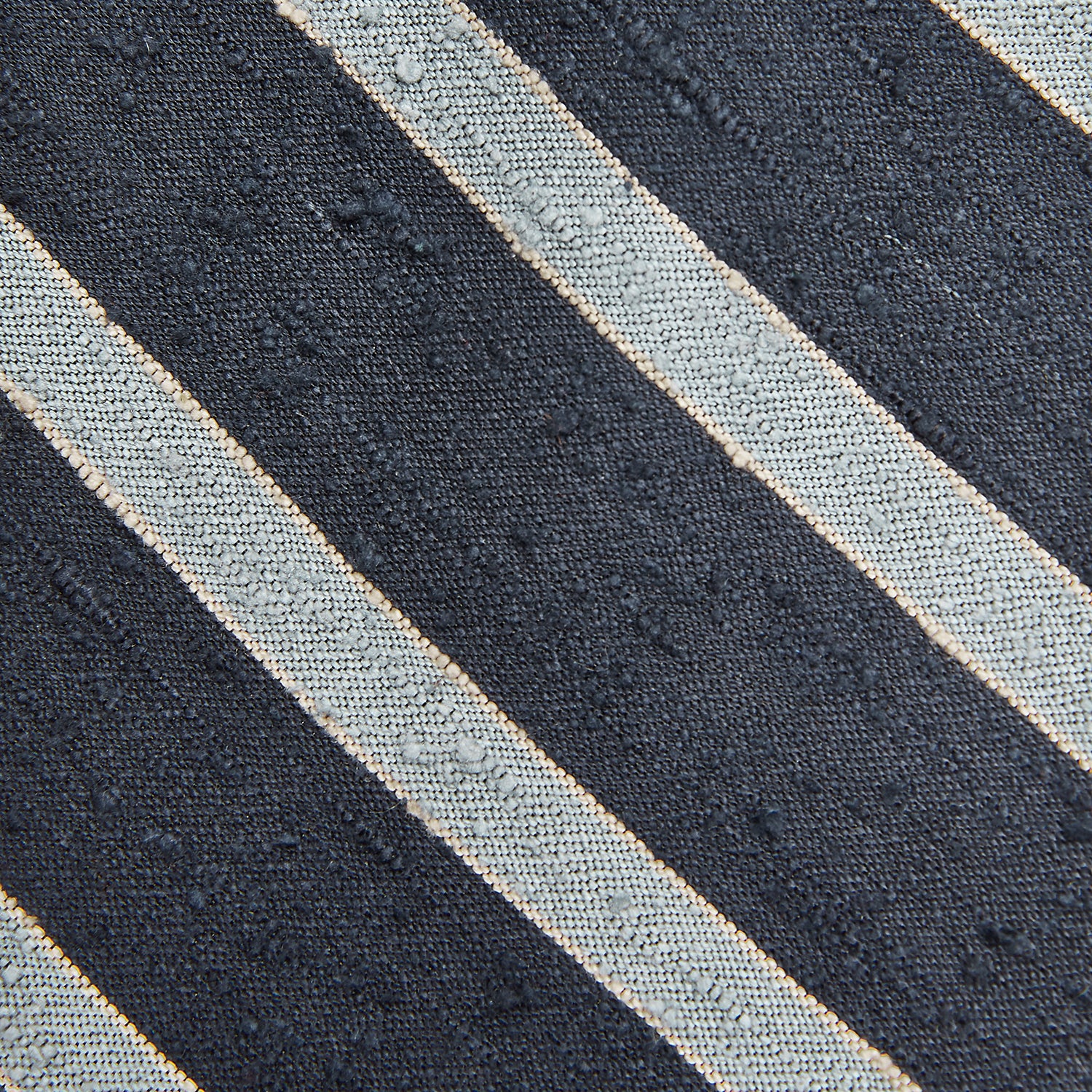 View 3 of product The Turnbull & Asser Blue & Silver Stripe Silk Tie, featuring wide diagonal stripes, is rolled up and displayed against a plain white background.