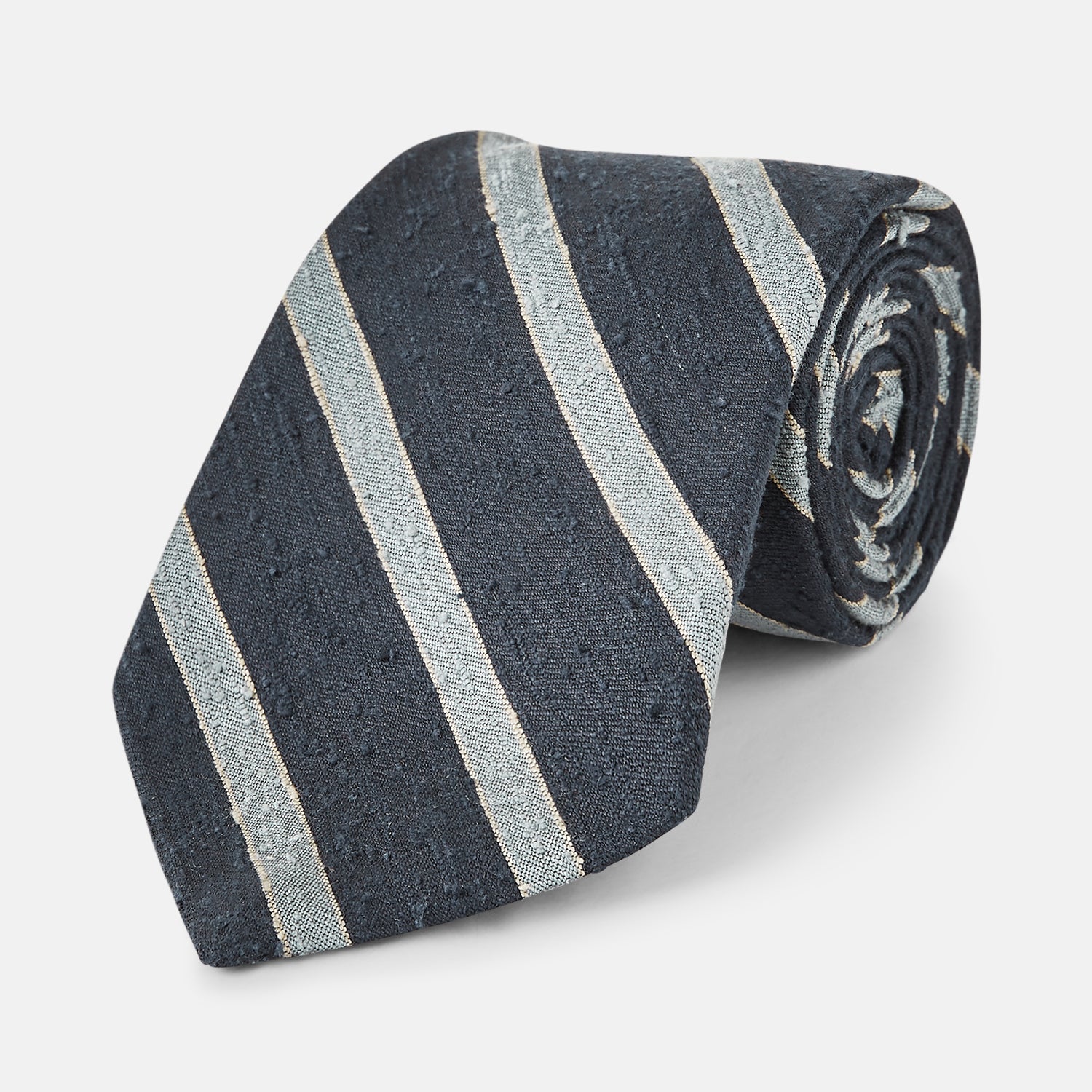 View 1 of product The Turnbull & Asser Blue & Silver Stripe Silk Tie, featuring wide diagonal stripes, is rolled up and displayed against a plain white background.