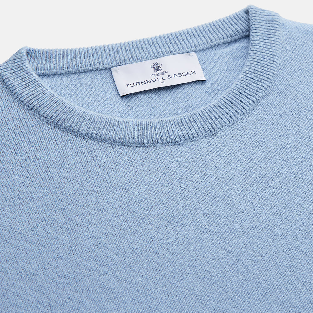 The Pale Blue Cashmere Glenn Jumper by Turnbull & Asser is laid flat against a white background. This men's crew neck essential features ribbed cuffs, hem, and neckline for timeless style.