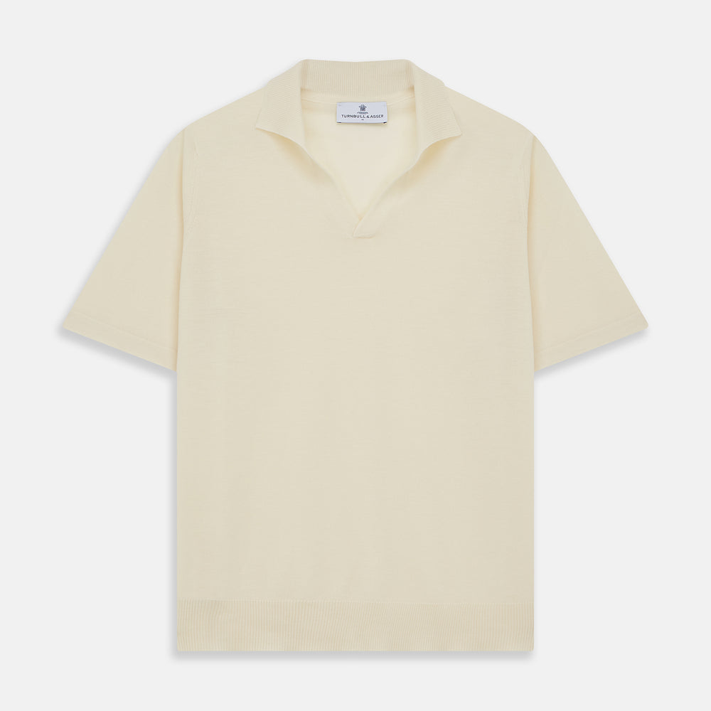 The Turnbull & Asser Ecru Merino Wool Roland Polo Shirt, made in Scotland, features soft merino wool, short sleeves, a relaxed open collar, and an inner neckline label. Shown here on a plain white background.