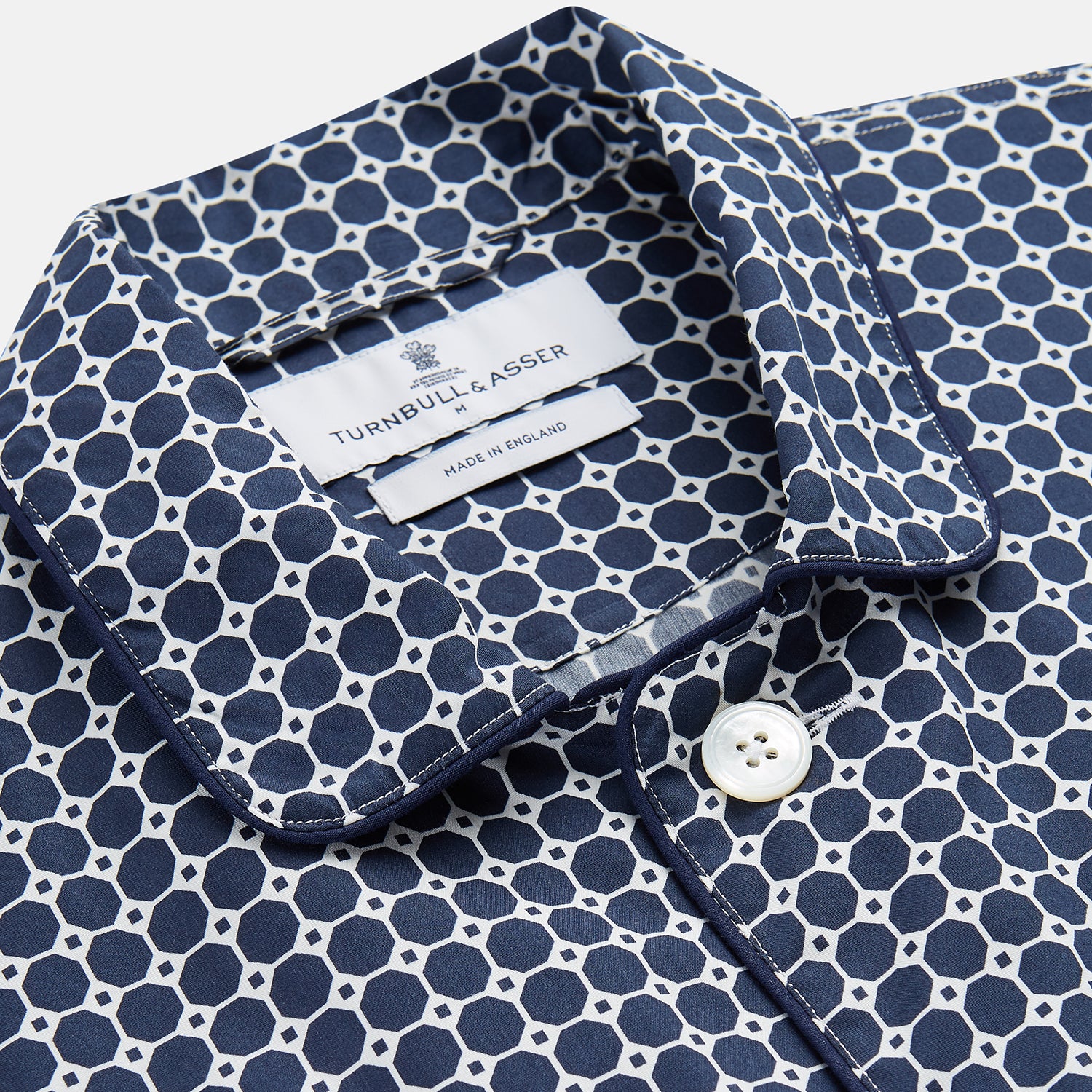 View 2 of product The Navy Motif Silk-Blend Hyde Pyjama Set by Turnbull & Asser features a blue and white pattern, long-sleeve button-up top with collar and front pocket, and matching pants, all displayed against a white background.