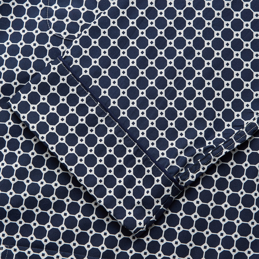 The Navy Motif Silk-Blend Hyde Pyjama Set by Turnbull & Asser features a blue and white pattern, long-sleeve button-up top with collar and front pocket, and matching pants, all displayed against a white background.