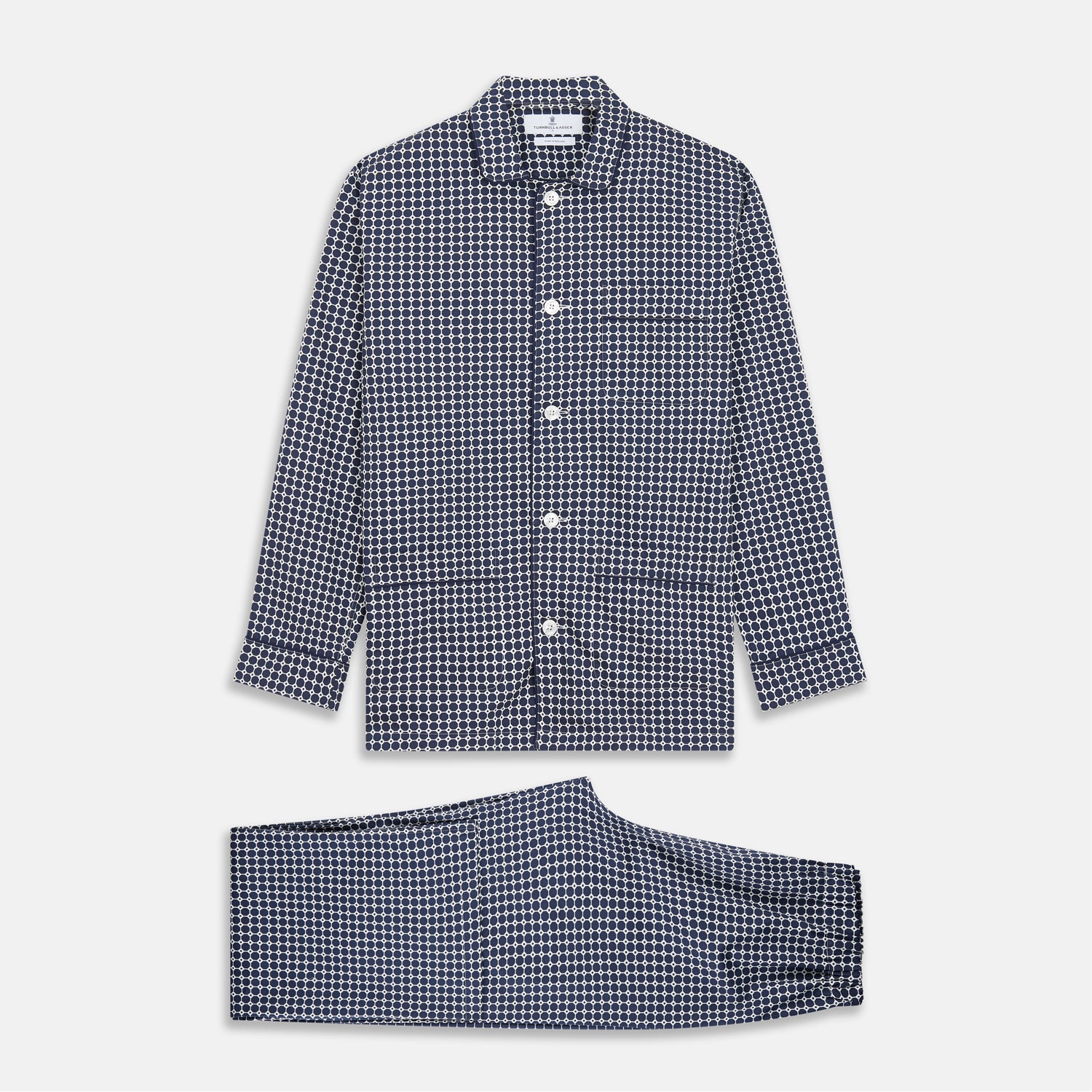 View 1 of product The Navy Motif Silk-Blend Hyde Pyjama Set by Turnbull & Asser features a blue and white pattern, long-sleeve button-up top with collar and front pocket, and matching pants, all displayed against a white background.